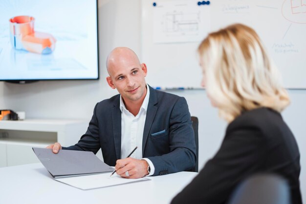 Geschäftsmann und Geschäftsfrau, die im Büro sprechen