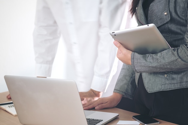 Geschäftsmann und Geschäftsfrau, die zusammen an Laptop arbeiten