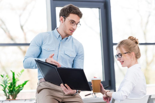 Geschäftsmann und Geschäftsfrau, die zusammen mit Dokumenten in einem modernen Büro arbeiten