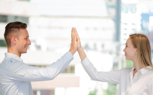 Geschäftsmann und Geschäftsfrau geben sich die Hand, um im Geschäft zusammenzuarbeiten. Junge kaukasische Stapel von Händen, die Einheit und Teamarbeit zeigen