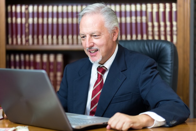 Geschäftsmann unter Verwendung seines Laptops in einer Bibliothek