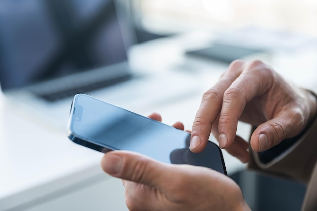 Geschäftsmann verwendet Handy-Hintergrund-Laptop