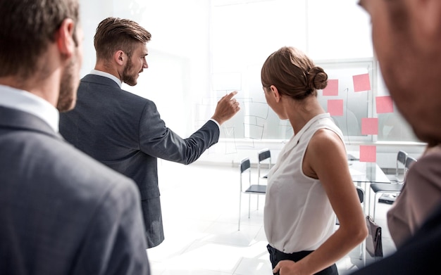 Foto geschäftsmann zeigt auf die notizen für das business teambusiness-konzept