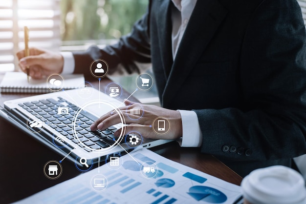 Geschäftsmannhände tippen auf digitaler Laptop-Computertastatur und machen sich Notizen, berechnen und analysieren Diagrammdokumente im Büro