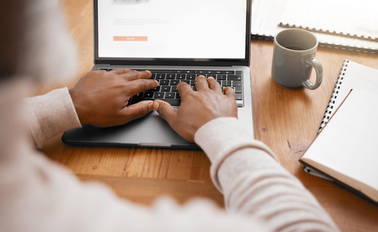 Foto geschäftsmannhände und laptop tippen eines unternehmensmitarbeiters mit arbeitsplatznotizen für das schreiben von e-mails und einer person mit notizbuch und forschungsanalyse zum online-lesen und karrierebericht