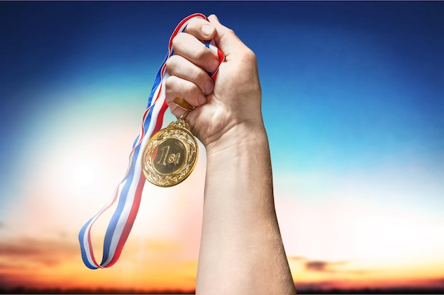 Geschäftsmannhand, die goldene Medaille hält