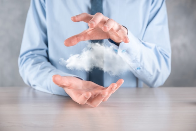 Geschäftsmannhand, die Wolke hält. Wolkencomputerkonzept, Nahaufnahme des jungen Geschäftsmannes mit Wolke über seiner Hand.