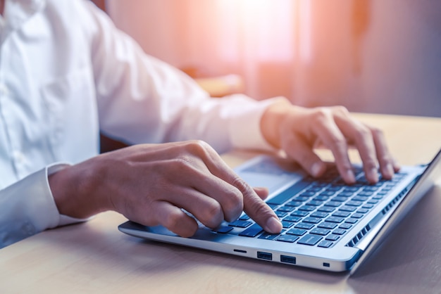 Geschäftsmannhand mit Laptop-Computer im Büro.