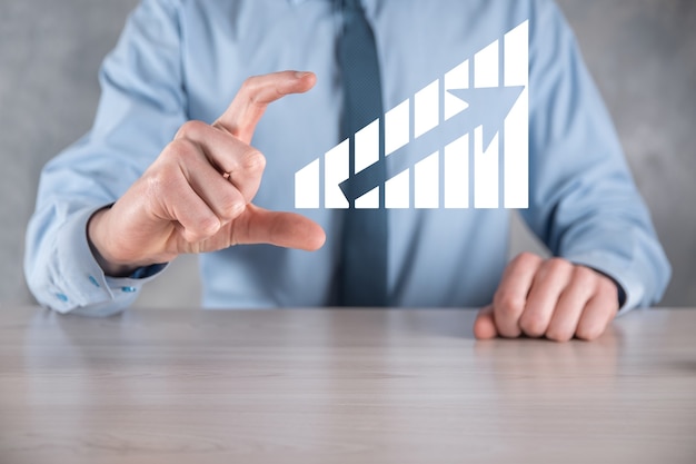 Geschäftsmannmann, der eine Grafik mit positivem Gewinnwachstum hält. Planen Sie das Wachstum des Diagramms und die Erhöhung der positiven Indikatoren des Diagramms in seinem Geschäft.