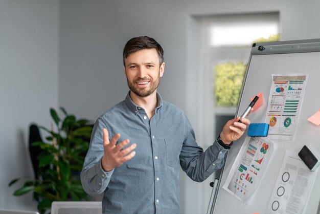 Geschäftsmöglichkeiten selbstbewusster Mann mittleren Alters, der eine Präsentation mit Grafiken und Diagrammen macht