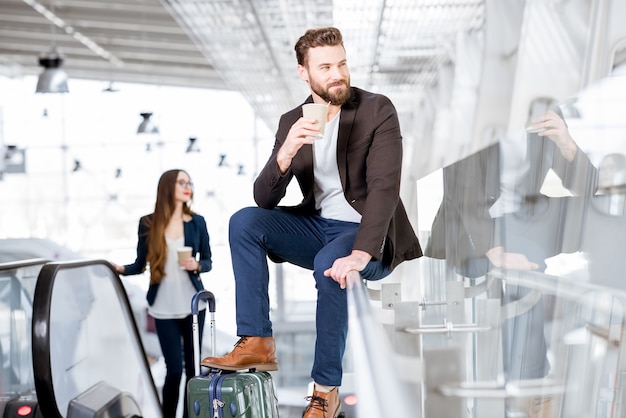 Geschäftspaar mit Kaffee zum Mitnehmen am Flughafen. Geschäftsreisekonzept