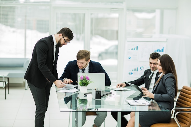 Geschäftspartner besprechen die Gewinne, bevor sie am Arbeitsplatz in einem modernen Büro einen neuen Vertrag unterzeichnen