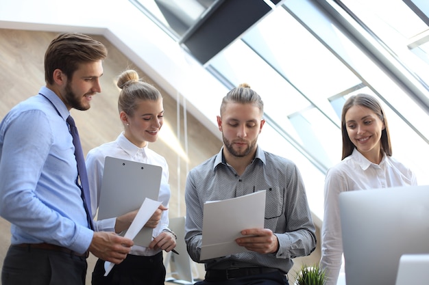 Geschäftspartner, die beim Treffen Dokumente und Ideen diskutieren.