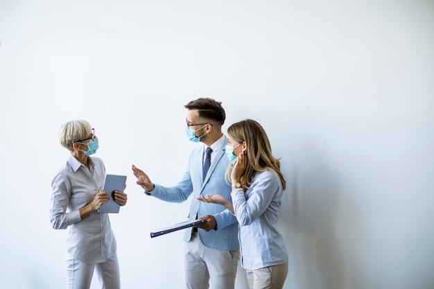 Geschäftspartner, die im büro stehen und geschäftsergebnisse betrachten, während sie gesichtsmasken tragen, sind ein virenschutz