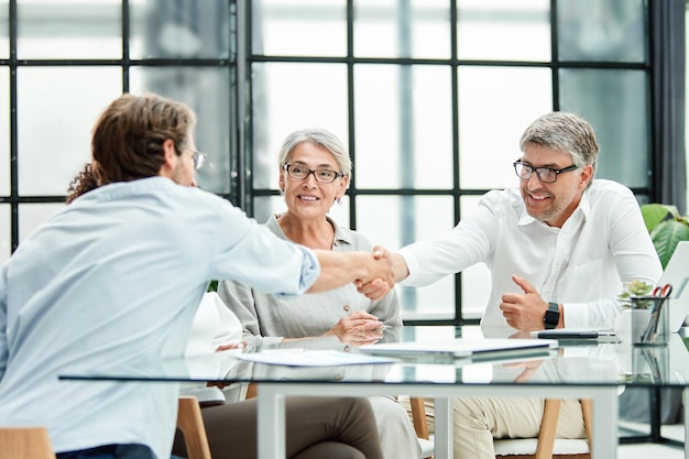 Geschäftspartner schütteln sich selbstbewusst das Konzept der Zusammenarbeit