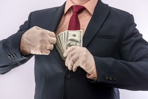 Geschäftsperson Hand in blauen Schutzhandschuhen mit Geld lokalisiert auf weißem Hintergrund