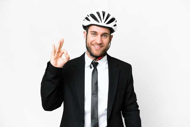 Geschäftsperson mit einem Fahrradhelm über isoliertem weißem Hintergrund, der mit den Fingern ein Ok-Zeichen zeigt