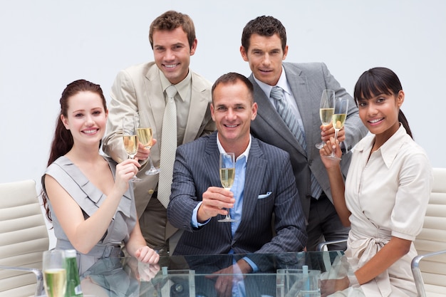 Geschäftsteam, das mit Champagner im Büro röstet