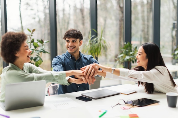 Geschäftsteam hält Händchen und vereint sich im Büro zur Unternehmensmission