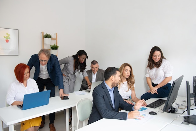 Geschäftsteam von Männern und Frauen in einem Büro, das die Entwicklung des Unternehmens analysiert