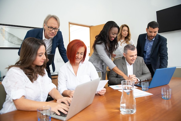 Geschäftsteam von Männern und Frauen in einem Büro, das die Entwicklung des Unternehmens analysiert