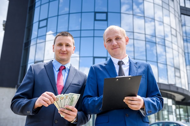 Foto geschäftsvertrag im freien, partner mit dollar-banknoten