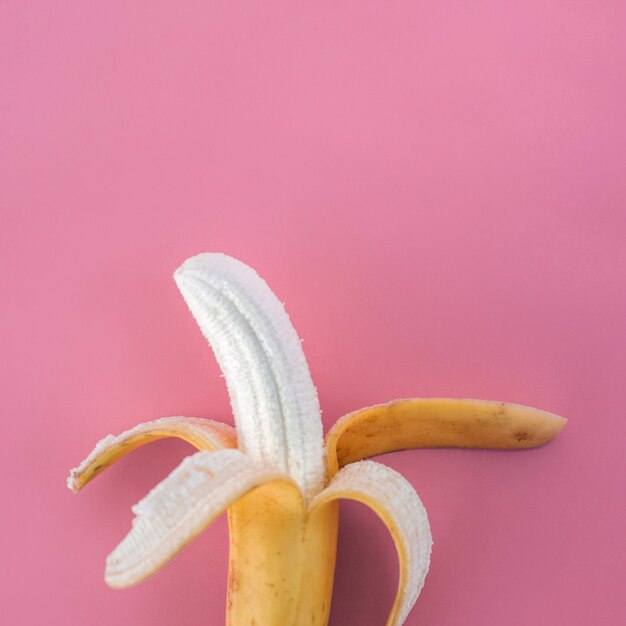 Geschälte Banane auf Rosa