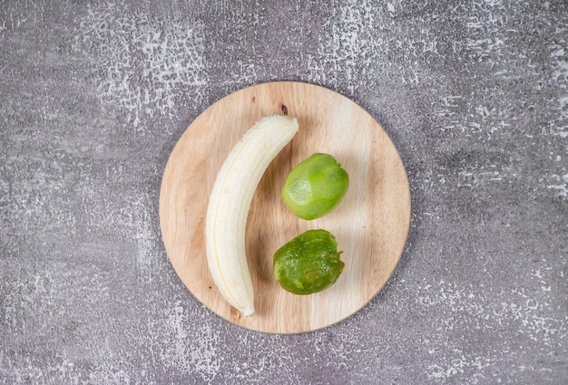 Geschälte Banane und Kiwi sind auf dem Schneidebrett.