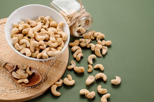 Geschälte Cashewnüsse in einem Weinkorb und auf einem Hintergrund verstreut