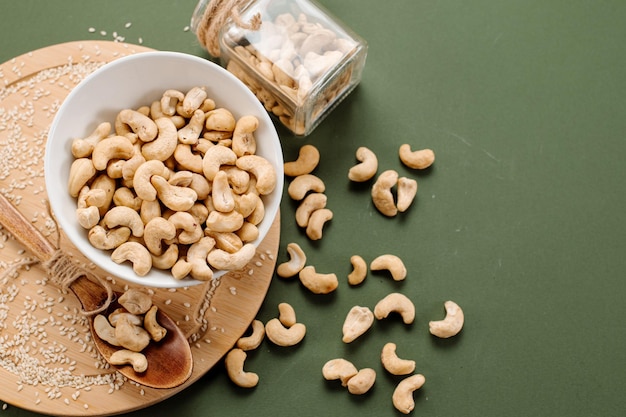 Geschälte Cashewnüsse in einem Weinkorb und auf einem Hintergrund verstreut