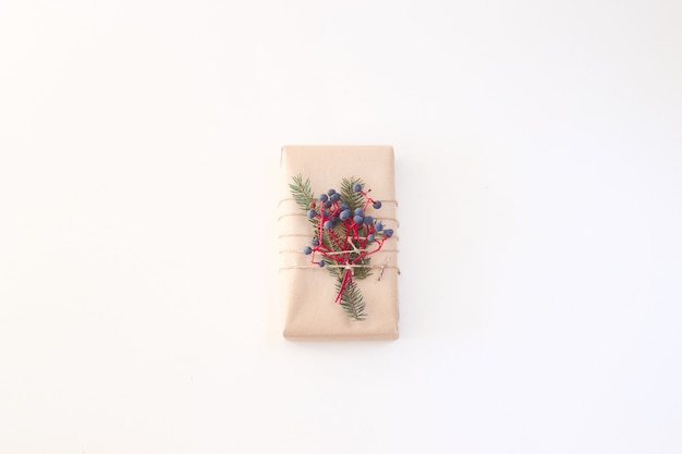 Geschenk des Weihnachtsneuen Jahres verziert mit Kraftpapier und Beeren