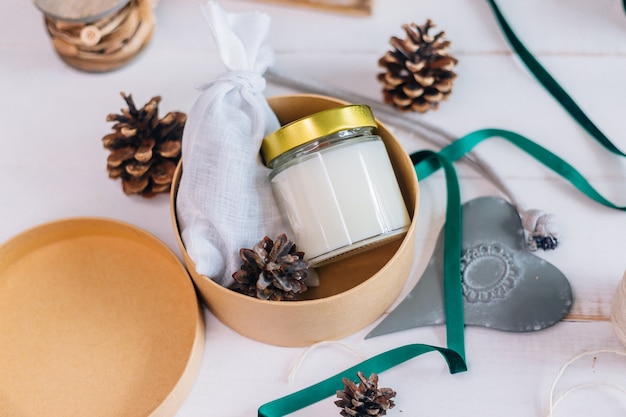 Geschenk in einer Schachtel für Weihnachtskerze mit Holzdocht im Glas und Duftsäckchen