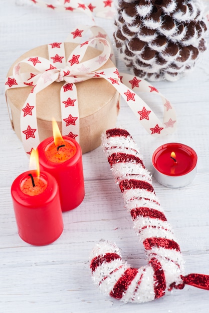 Geschenk in Kraftbox mit rotem Sternenband, brennenden Kerzen und Dekorationen
