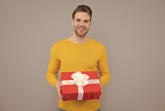 Geschenk machen Glücklicher Kerl hält Geschenkbox