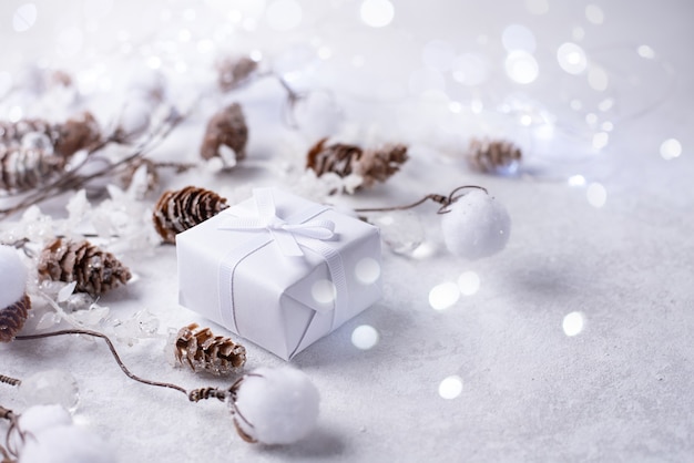 Geschenk mit Zweigen in Frost und Lichtern Bokeh auf weißem Hintergrund Weihnachten und Winter Hintergrund