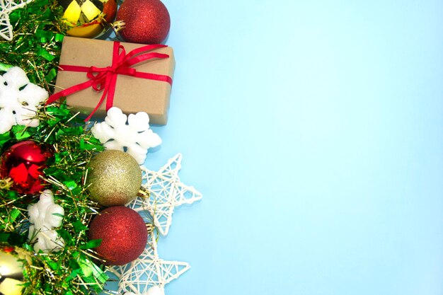 Geschenk- und Weihnachtsschmuck auf blauem Grund. Geschenkbox mit rotem Band.