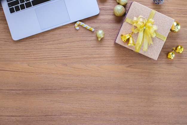 Geschenkbox auf Holztisch und Laptop.