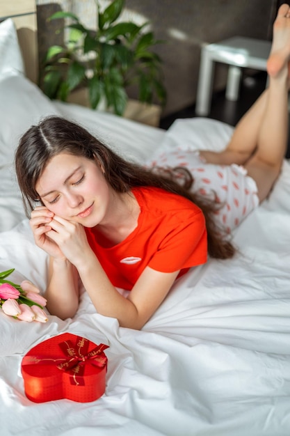 Geschenkbox in form eines herzens, die einer jungen frau am valentinstag geschenkt wird