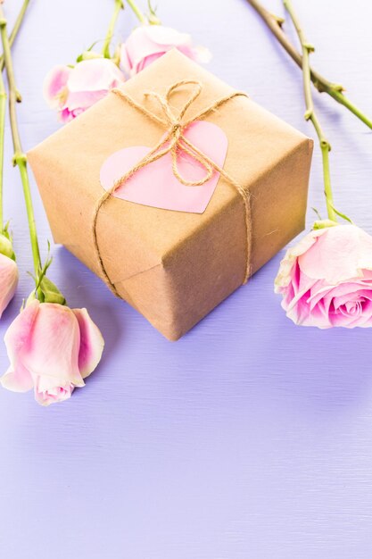 Geschenkbox in Recyclingpapier verpackt und mit rosa Herzen mit rosa Rosen verziert.