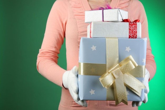 Geschenkbox in weiblicher Hand auf farbigem Hintergrund