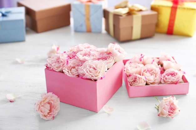 Geschenkbox mit Blumen auf Holztisch