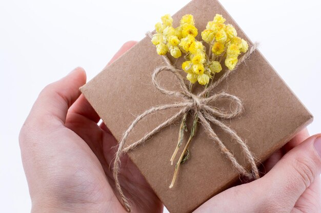 Geschenkbox mit Blumen in der Hand