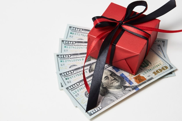 Geschenkbox mit Dollar-Banknoten auf weißem Hintergrund. Dollar-Geld-Geschenk