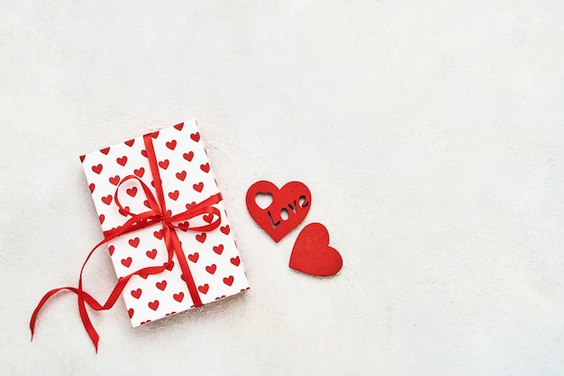 Geschenkbox mit Herzen und rotem Band. Valentinstag Konzept. Flache Lage, Kopierraum