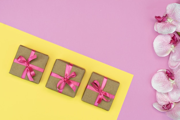 Geschenkbox mit rosa Band und Orchideenblüten