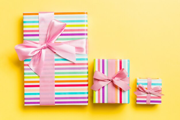 Geschenkbox mit rosa Bogen für Weihnachten auf Gelb