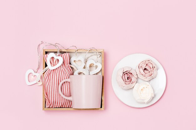 Geschenkbox mit rosa tasse, marshmallow und überraschung im textilbeutel