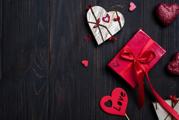 Geschenkbox mit rotem Bogenband und hölzernem Herzen