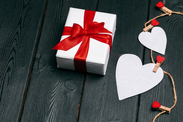 Geschenkbox mit roten Bogenband- und -papierherzen für Valentinstag