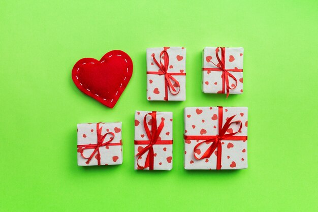 Geschenkbox mit roten Herzen auf grünem Hintergrund. Draufsicht mit Kopienraum